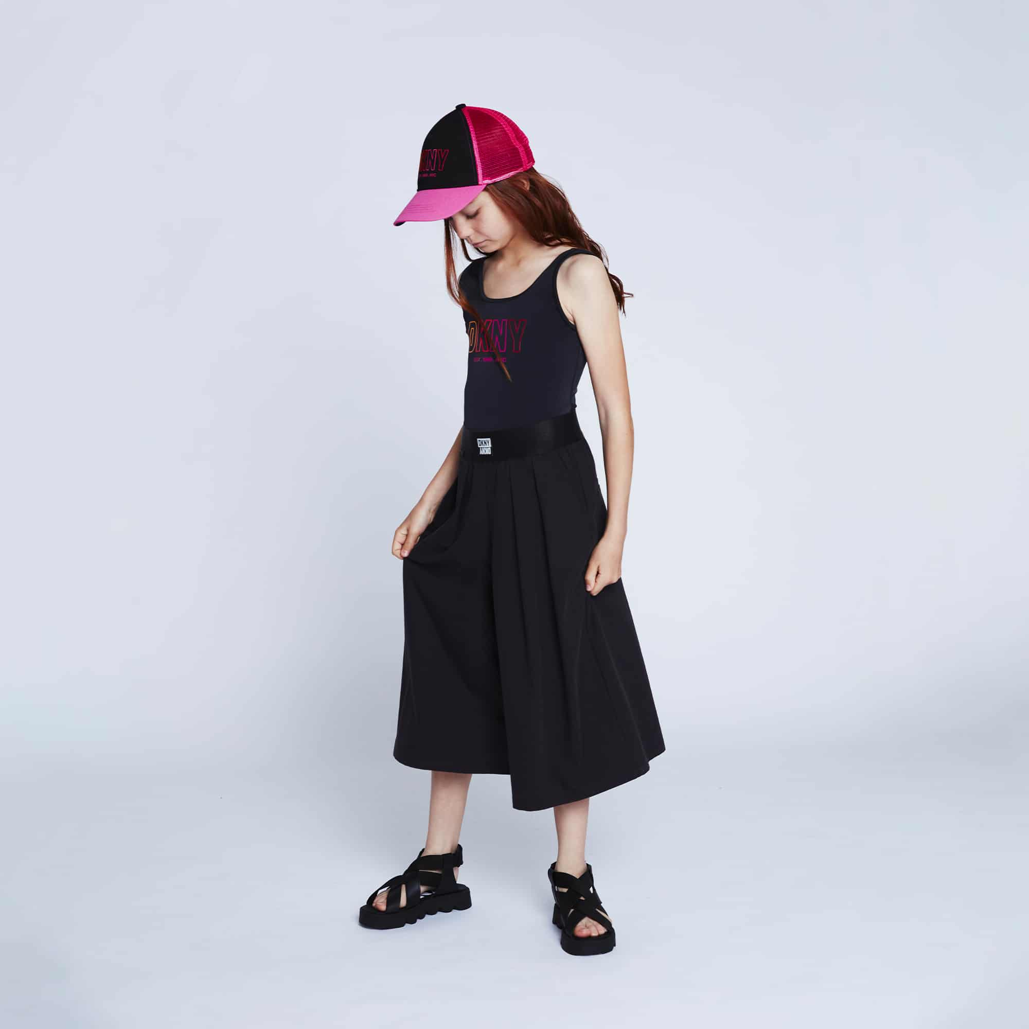 DKNY girls model in black outfit and baseball cap