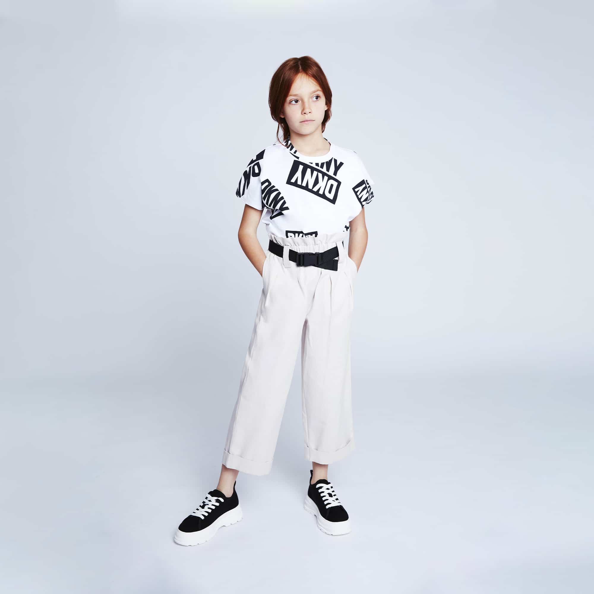 model in DKNY girls tshirt with multiple logos