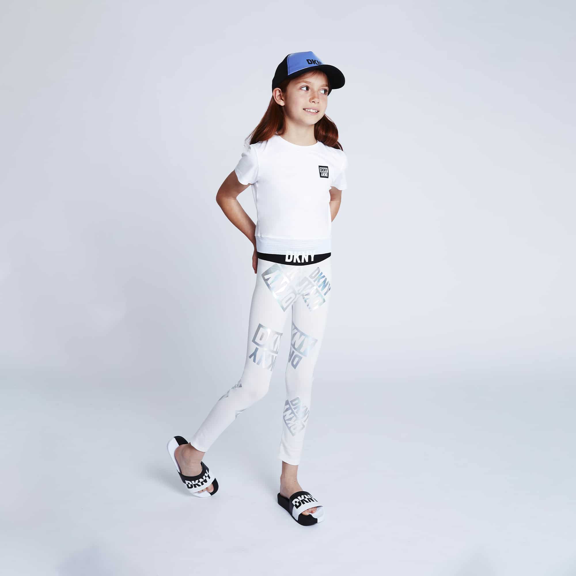 DKNY girl model in white leggings and cap