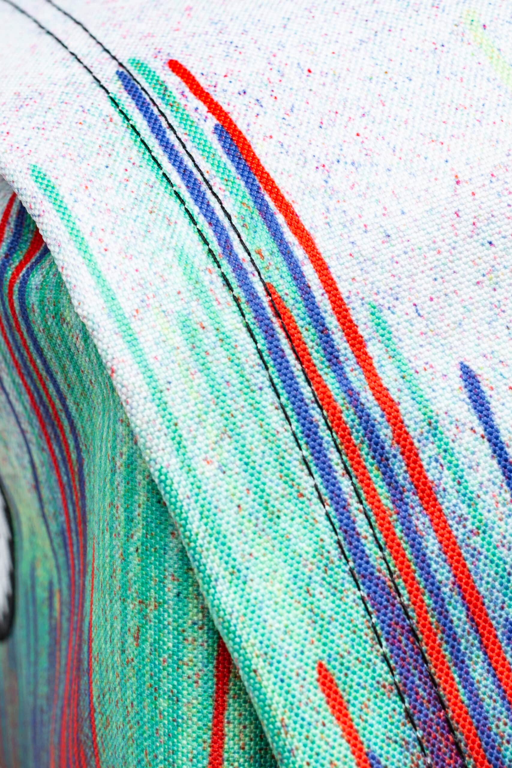 Hype red blue and green paint drip backback seam close up