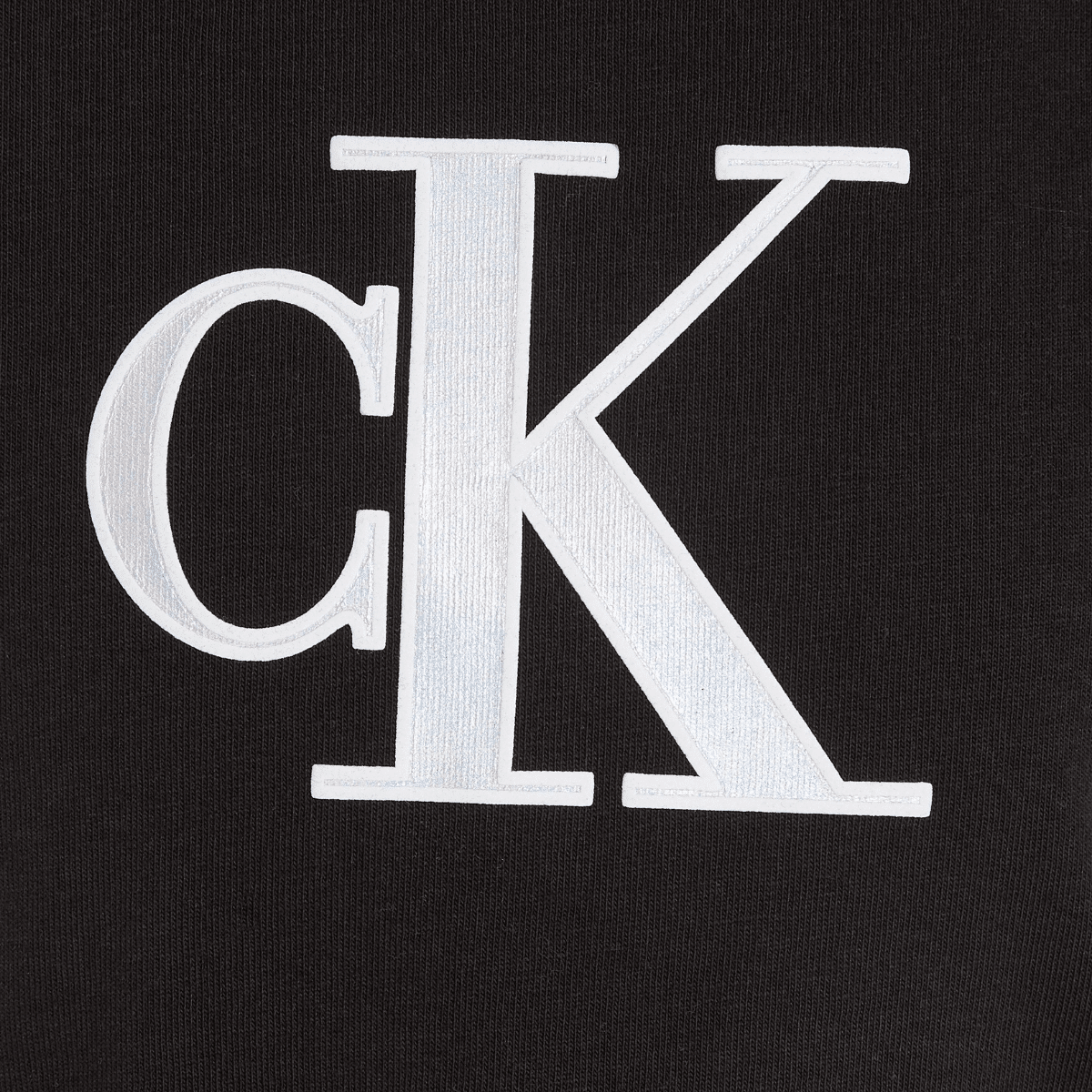 calvin klein large metallic CK logo close up on girls black tshirt
