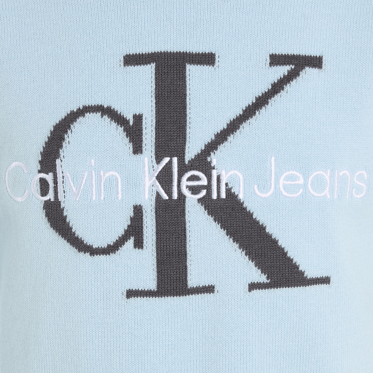 calvin klein childrens jeans logo close up on pale blue jumper
